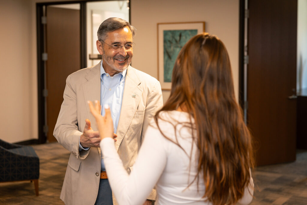 A man smiles while talking to a woman