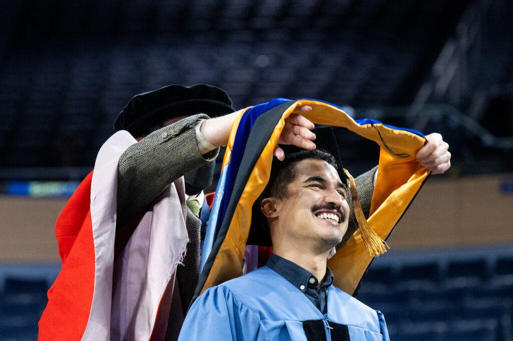 Student receives graduate hood.