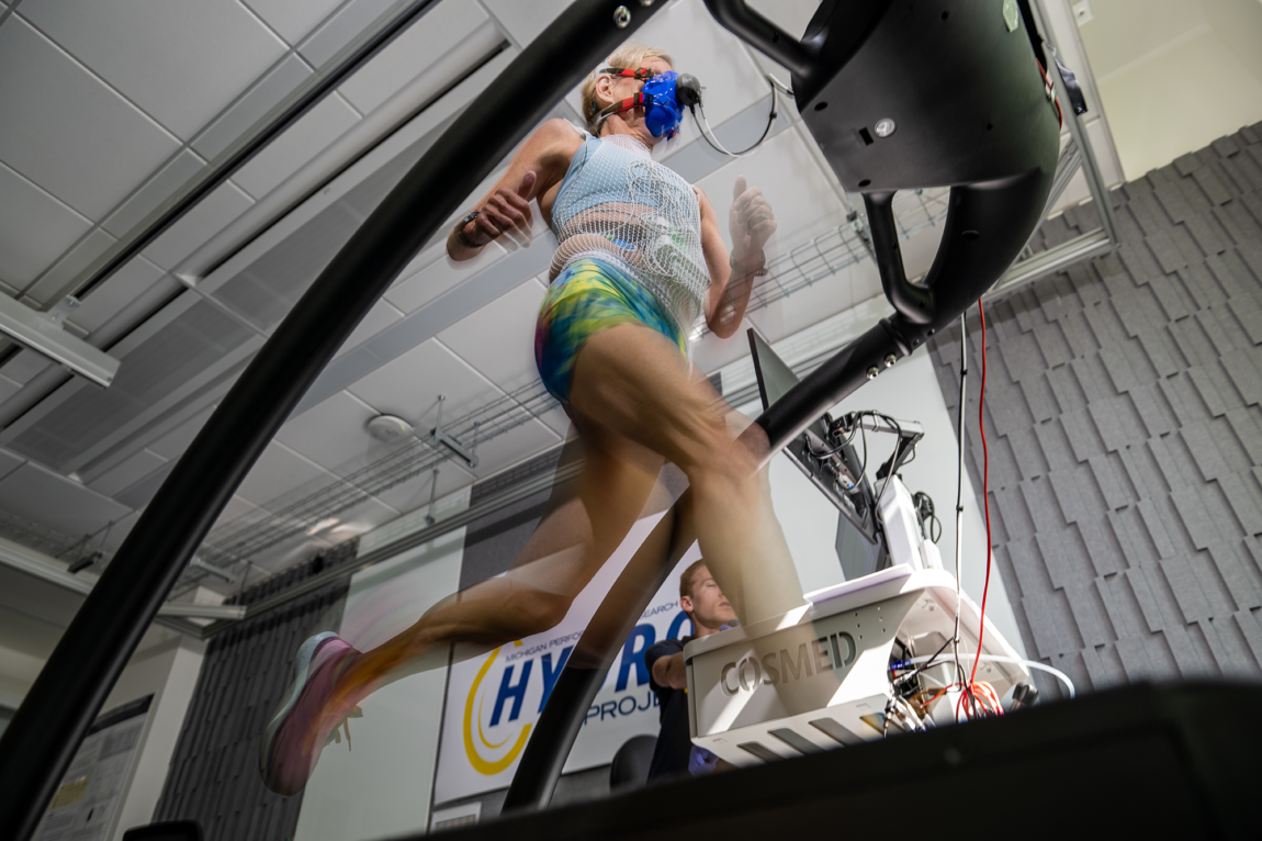 A woman running on a treadmill while wearing a breathing apparatus