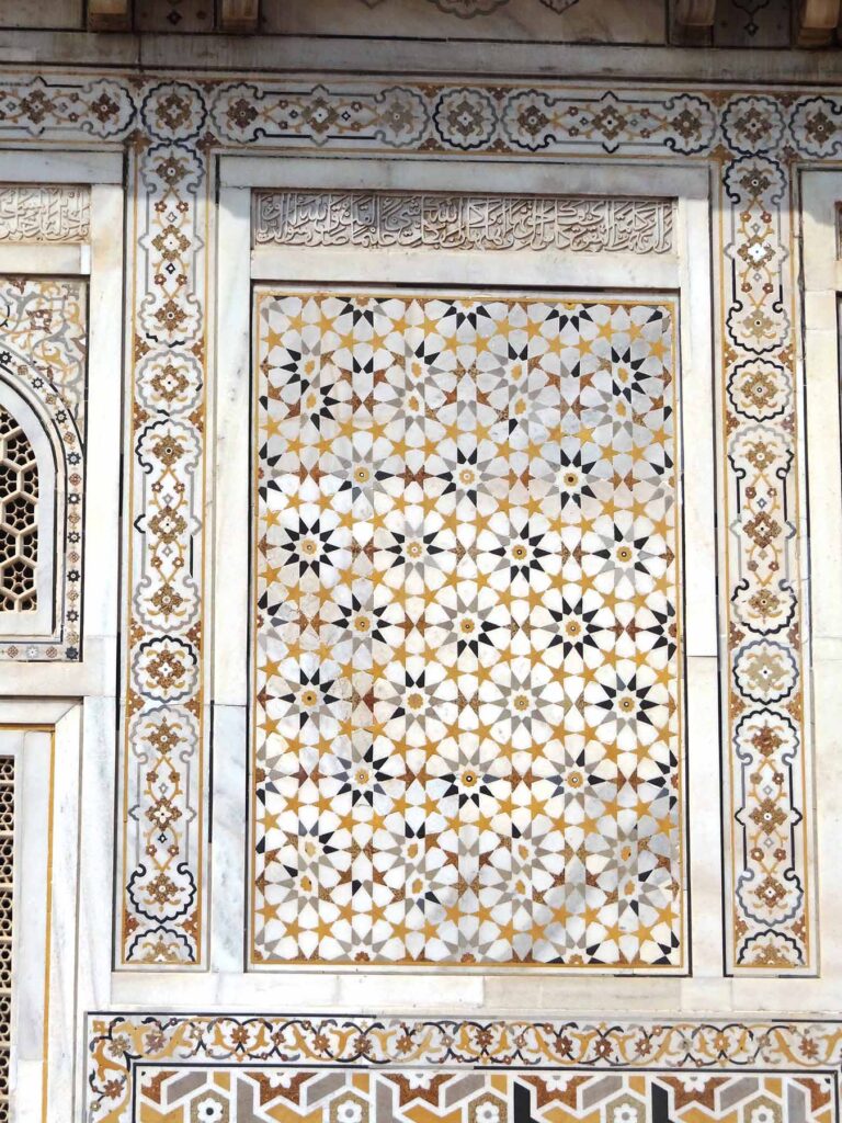 While the symmetry of quasicrystals preclude sequential patterns, their atoms still form repeating motifs similar to the patterns in traditional islamic tile art. This panel on the Tomb of I'timād-ud-Daulah in Agra, India is one example—each individual building block doesn't repeat in a regular sequence from left to right, nor up and down, but the ten-pointed star repeats across the panel. Image credit: Anupamg, CC BY-SA 4.0, via Wikimedia Commons
