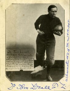 Vintage photograph, circa 1920, of Dr. Tom Lovell of Ann Arbor, dressed in football gear of the time, with ball tucked into his left arm.