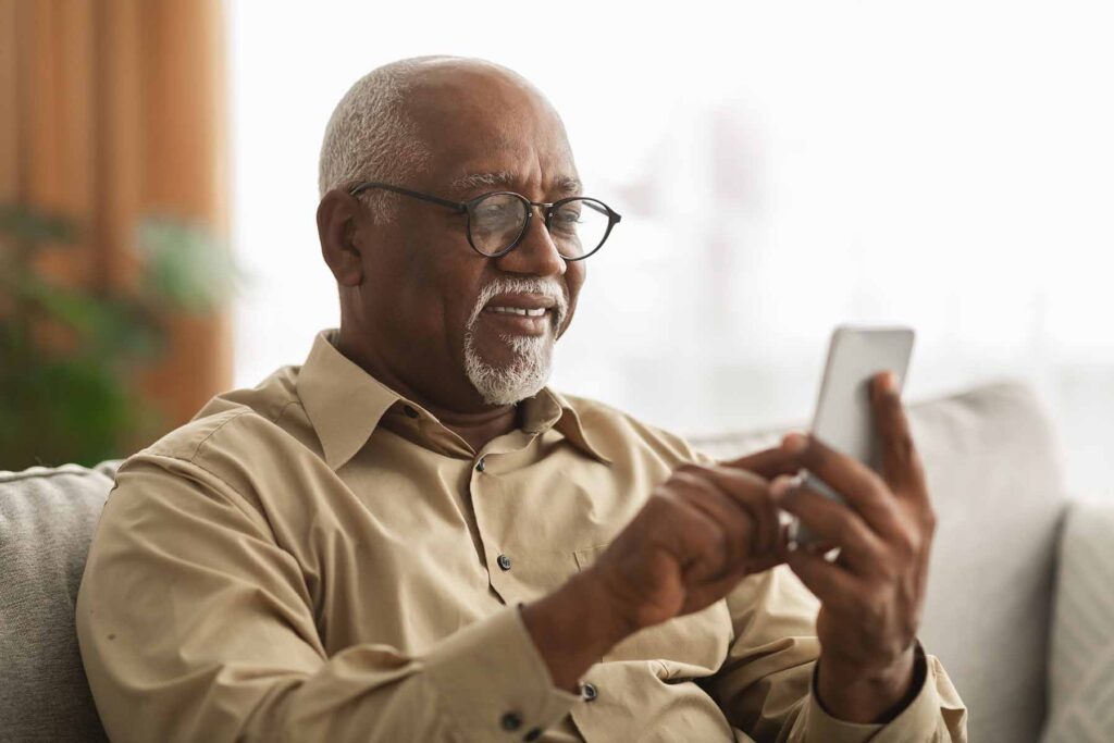 A senior man using his smartphone. Image credit: Adobe Stock