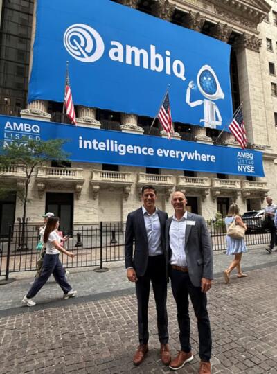 Two co-founders of University of Michigan startup Ambiq Micro—Scott Hanson, U-M engineering alum and Ambiq chief technology officer, and Dennis Sylvester, U-M professor and chair of electrical and computer engineering, pose in front of a banner celebrating Ambiq’s IPO at the New York Stock Exchange on July 30, 2025. Image courtesy: Dennis Sylvester