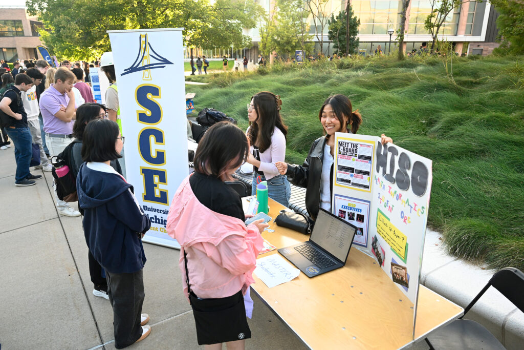 People approach a table with information