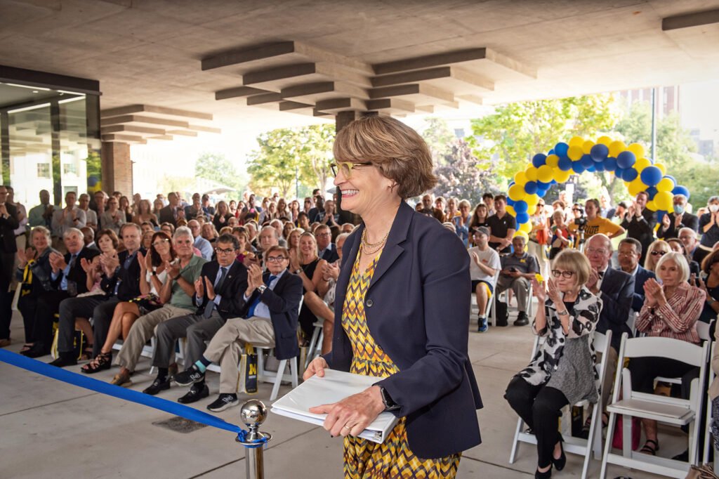 A woman stands before a crowd of people