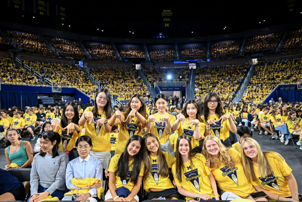 People smile while attending the New Student Convocation at Crisler Center