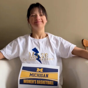 Girl holds Michigan Women's Basketball sign.