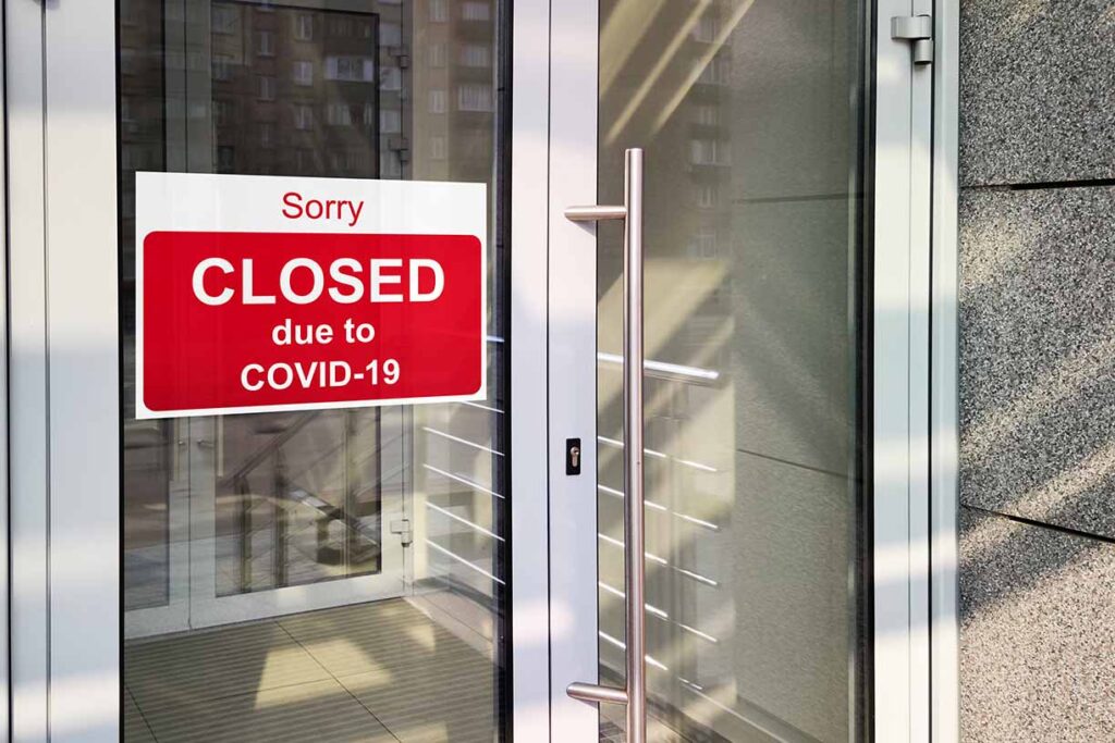 Business center closed due to COVID-19 coronavirus, sign with sorry in door window. Stores, restaurants, offices, other public places temporarily closed. Image credit: Adobe Stock