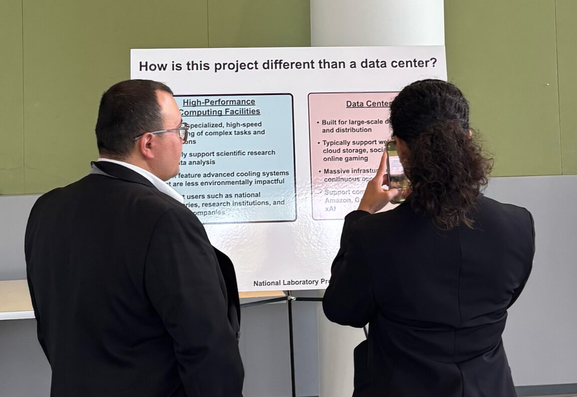 Two people read a posterboard with information