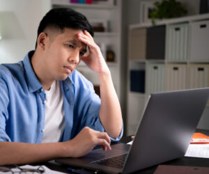 Perplexed man looks at computer screen.