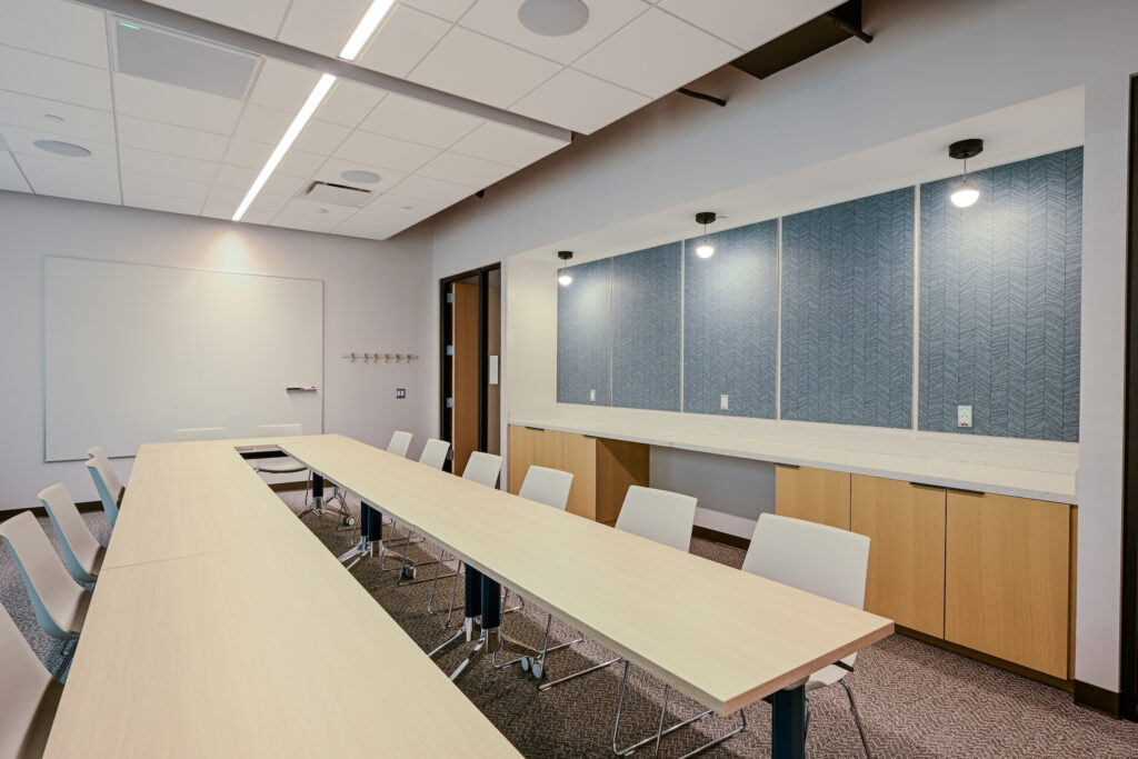 A conference room with two long tables and many chairs