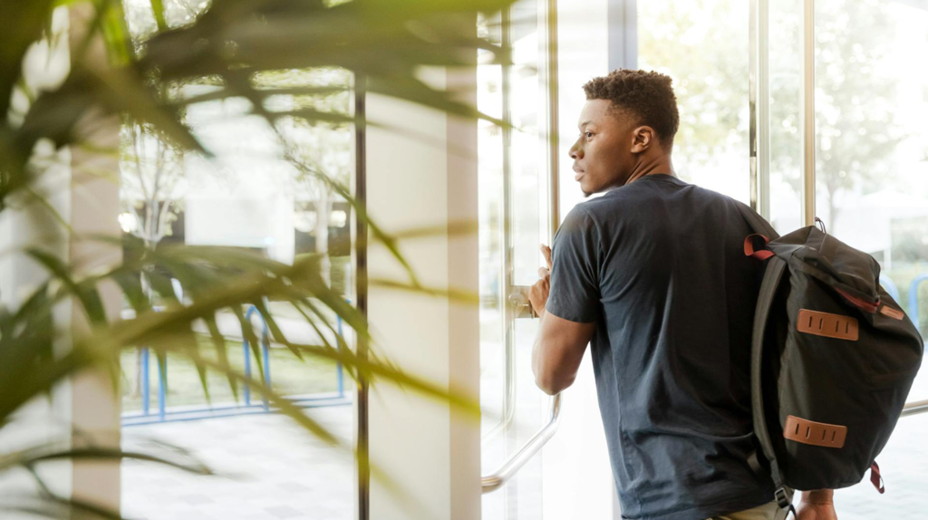 A young man looking out window. Image credit: LinkedIn Sales Navigator, Pexels