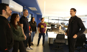 U-M grad and Brazilian swimming superstar Gustavo Borges speaks to a team of people.