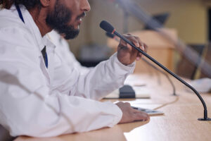Scientist speaks into a microphone as he testifies before Congress.