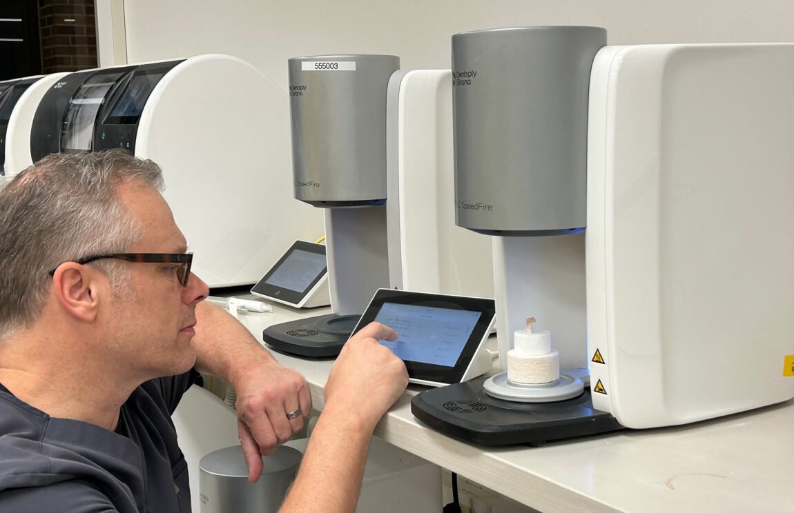 A man works on an iPad in a digital dentistry clinic