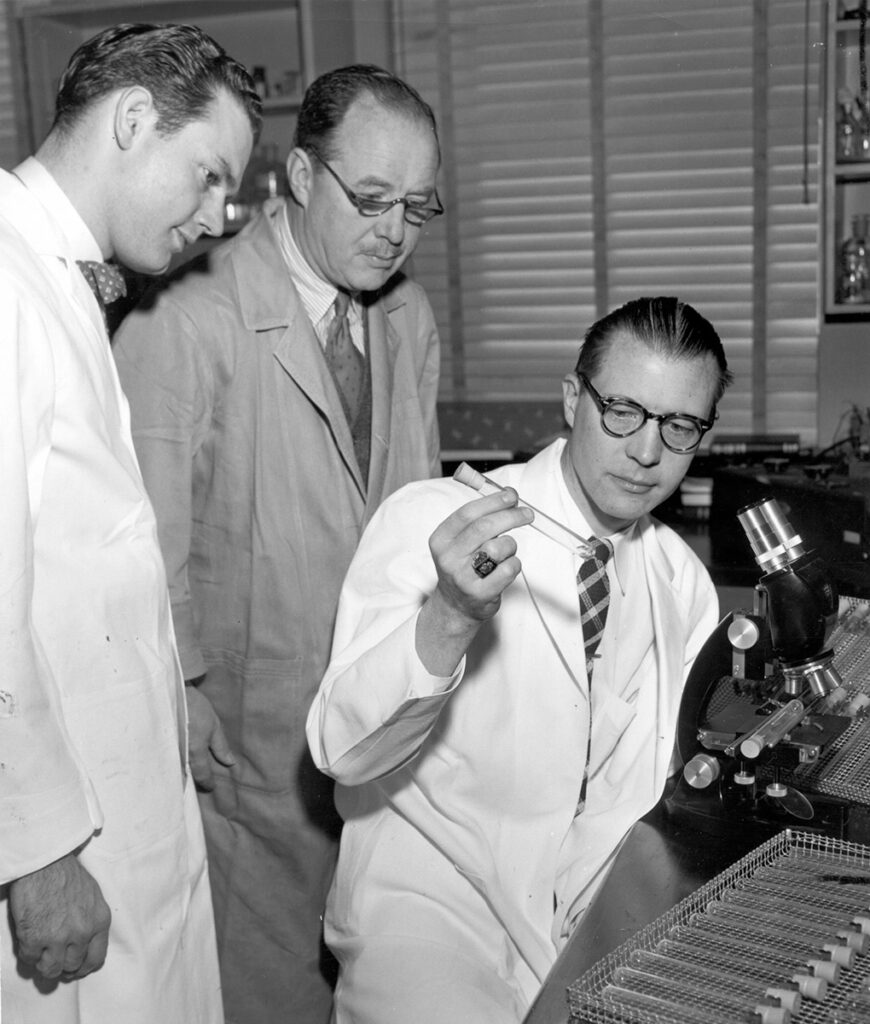 Thomas Francis examines a culture of the polio virus with fellow scientists Wilbur Ackerman and Gordon Brown 
