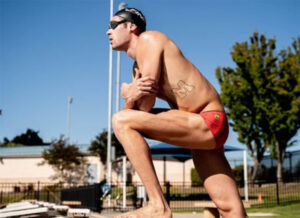 Profile image of a swimmer with Block M tattoo on his side to represent the University of Michigan.