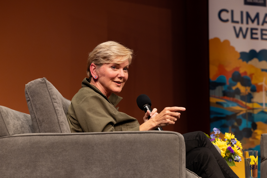 A woman sitting in a chair talks into a microphone