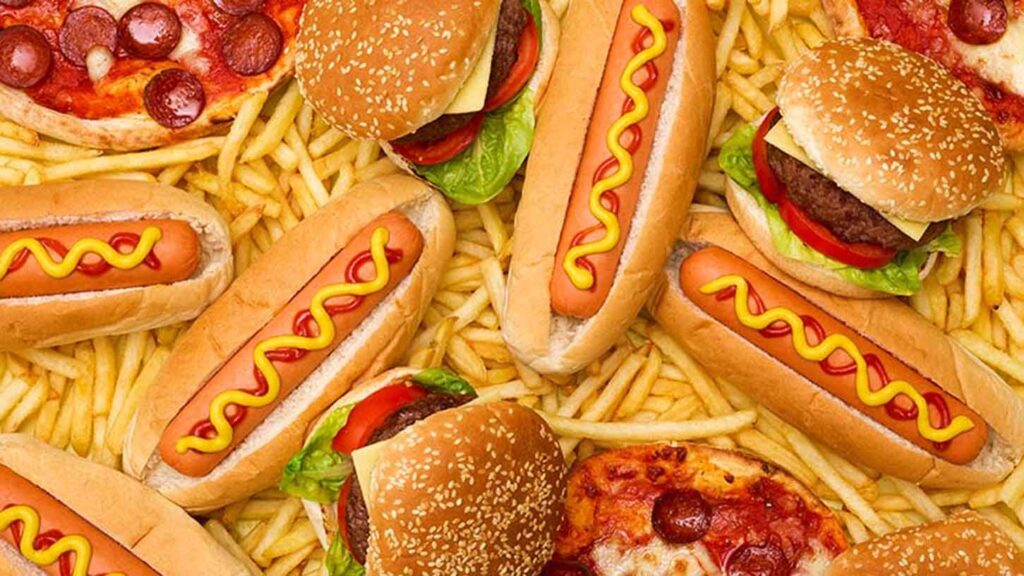 Overhead view of hamburgers, hot dogs, french fries and pizza. Image courtesy: U-M IHPI