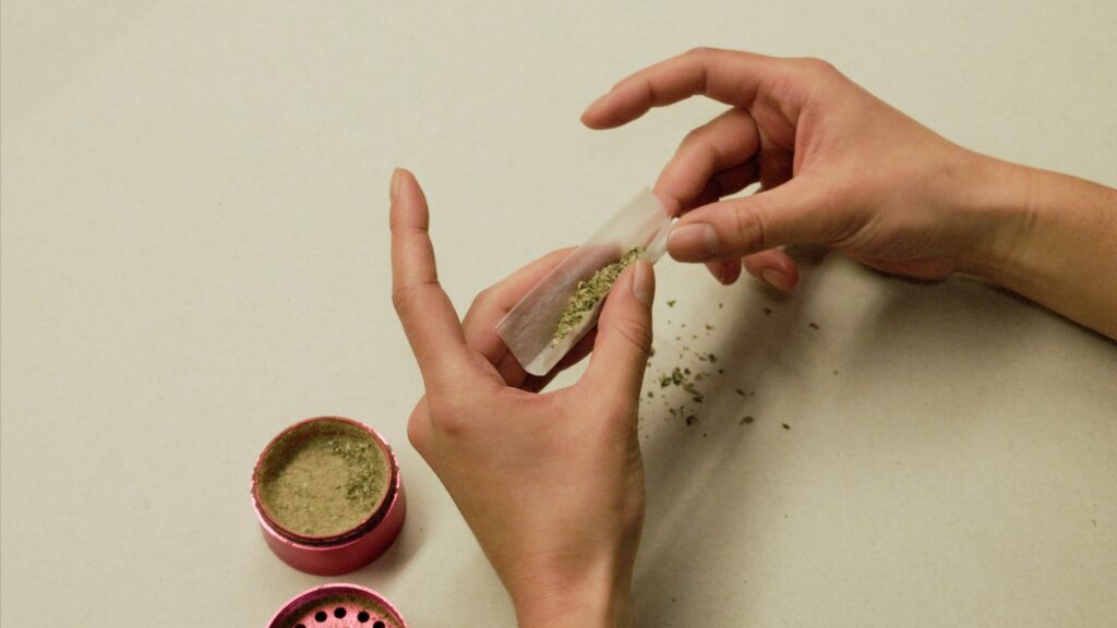 A person rolling a marijuana joint. Image credit: Jeremy Marble, Michigan News