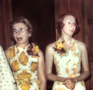 Two caucasian women dressed up and wearing corsages are pictured at U-M's Martha Cook Building in 1973.
