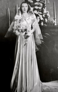 Black and white photo of woman in satin wedding gown.