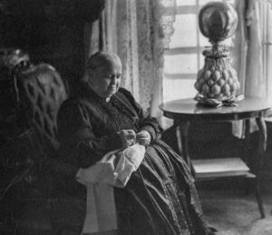 Martha Wolford Cook pictured in the 19th century, dressed in period garb in an elegant setting.