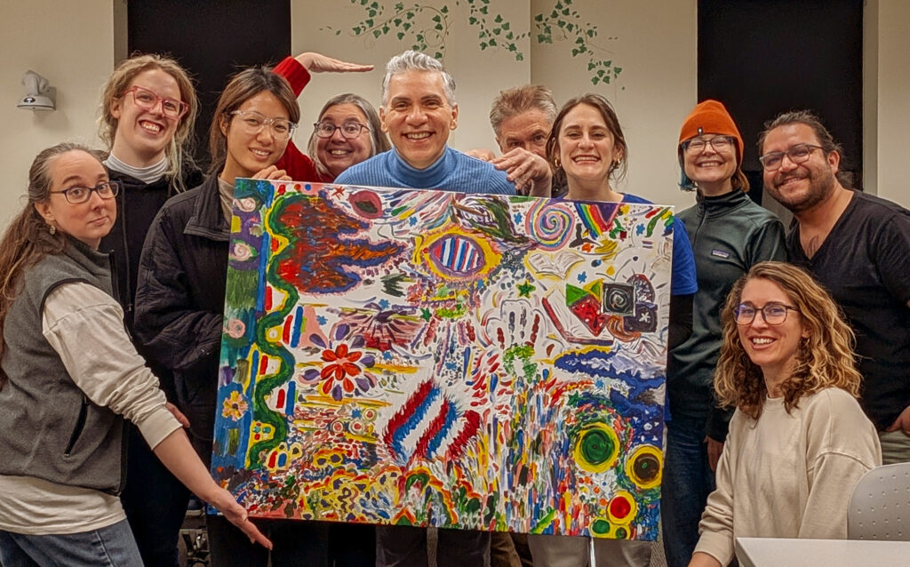 Rogério M. Pinto with Dream Flag participants and the painted flag they created together.