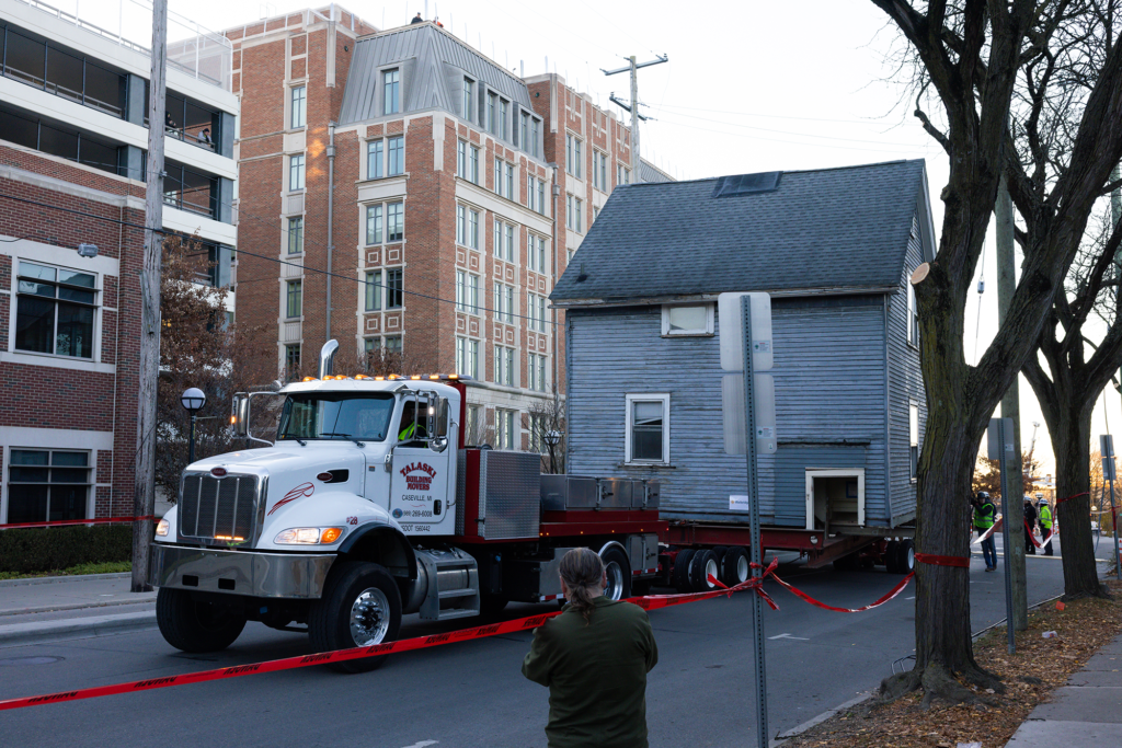 A house is hauled down the street by a trailer