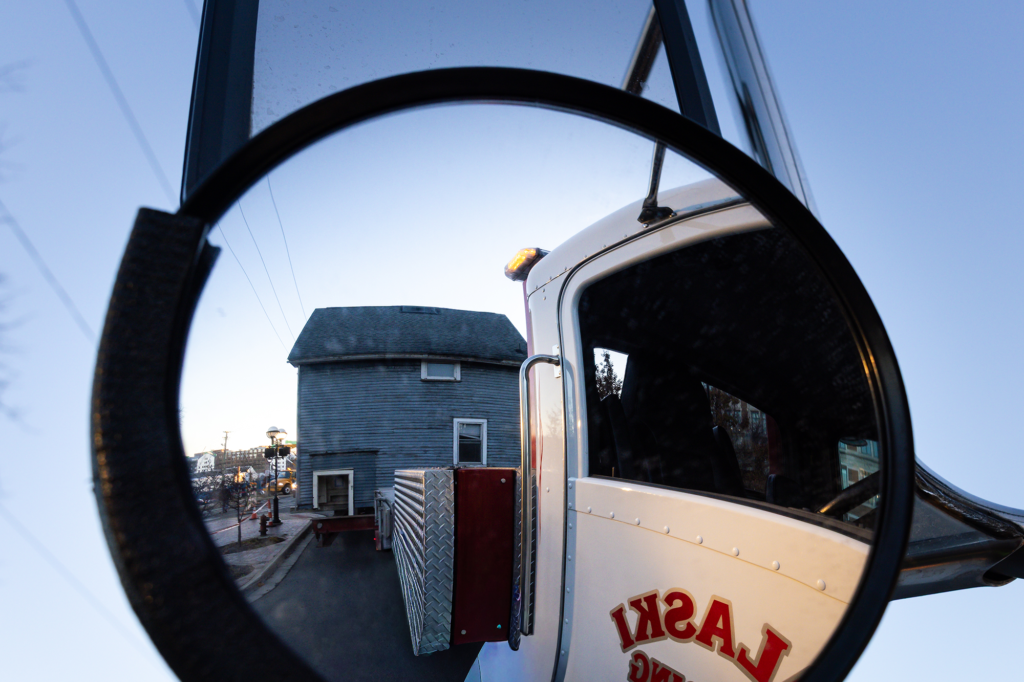 A house is seen being hauled by a trailer through a mirror