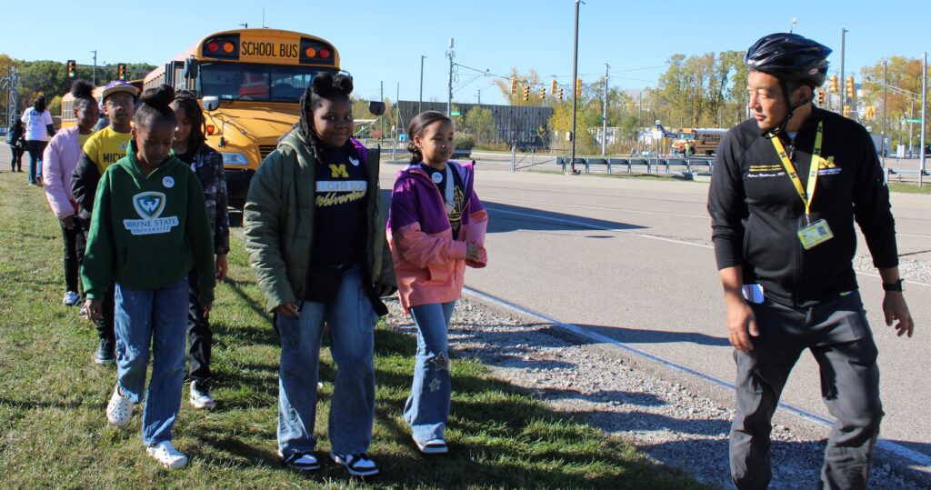 Andrew Hashikawa is escorting students from the school bus to the staging area. Image credit: Juan Ochoa