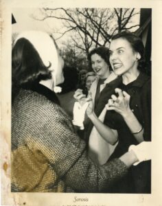 Black and white image of women in the early 20th century being very animated. Collegiate Sorosis.