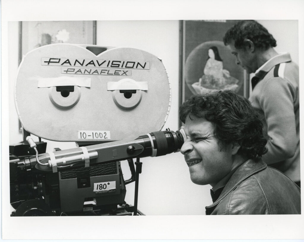 A man looking through a 1970s movie camera