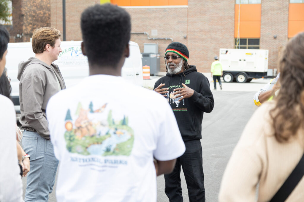 A man in a hat talks to students