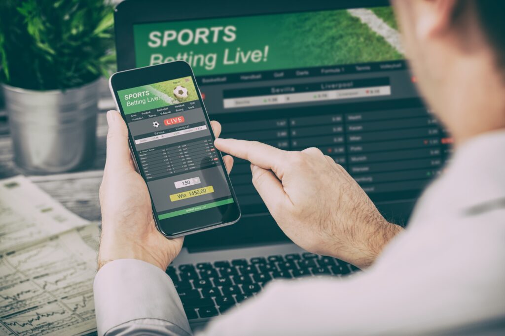 A man places a bet on a sports betting app. Image credit: Adobe Stock