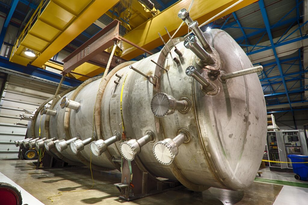 A metallic cylinder about the size of a school bus sits in the DZero Assembly Hall at Fermilab.