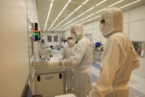 Three people are preparing the Pegasus-4 etching system dedicated to etching silicon using the Bosch process. Image credit: Jeremy Marble, Michigan News