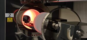 A glowing furnace which can reach 1100°C or higher, is open and ready to receive silicon wafers dedicated to growing or depositing films on silicon wafers, such as silicon dioxide. Image credit: Jeremy Marble, Michigan News