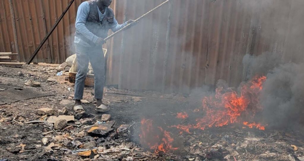 A man burns a pile of electronic waste, extracting metals to sell to local buyers, who then sell the valuable minerals back into the global supply chain. Informal recycling like this takes place without protection, regulation or registration with the state.