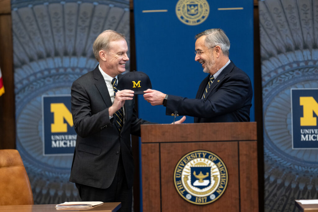 Two men at a podium celebrating an announcement