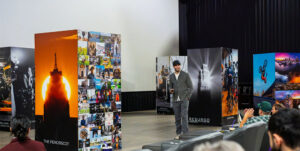 Filmmaker addresses crowd as he walks amid photo installation to promote his Detroit documentary Resurgo.