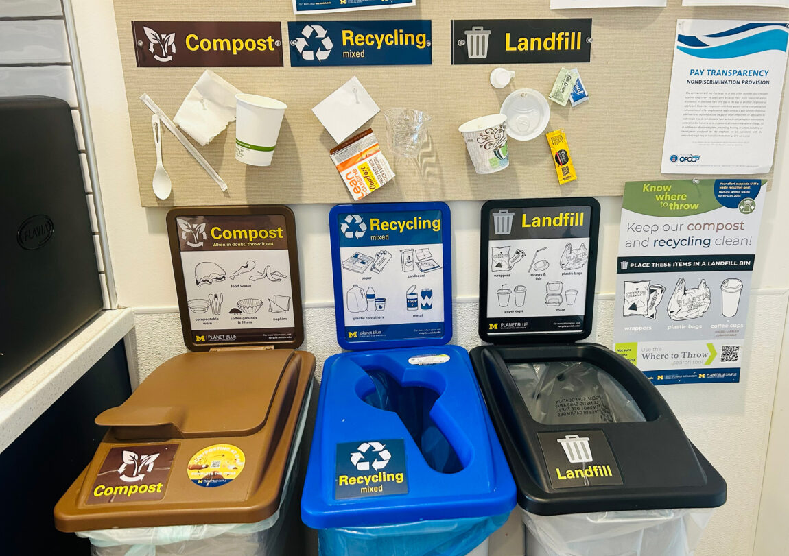 Waste bins with brown, blue and black tops indicating compost, recycling and landfill