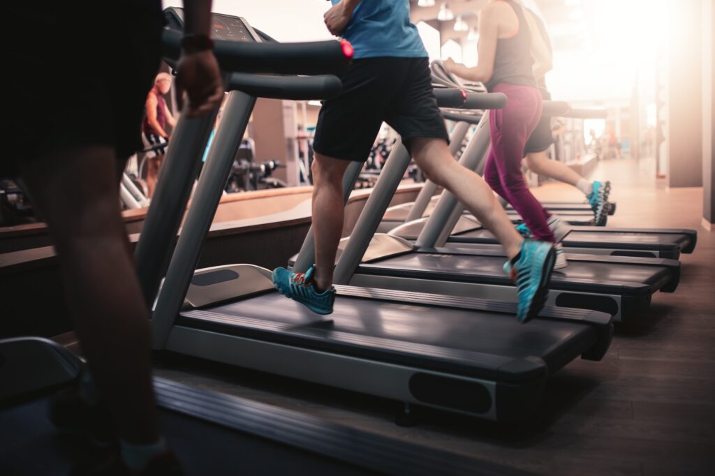 People running in machine treadmill at fitness gym club. Image credit: Adobe Stock